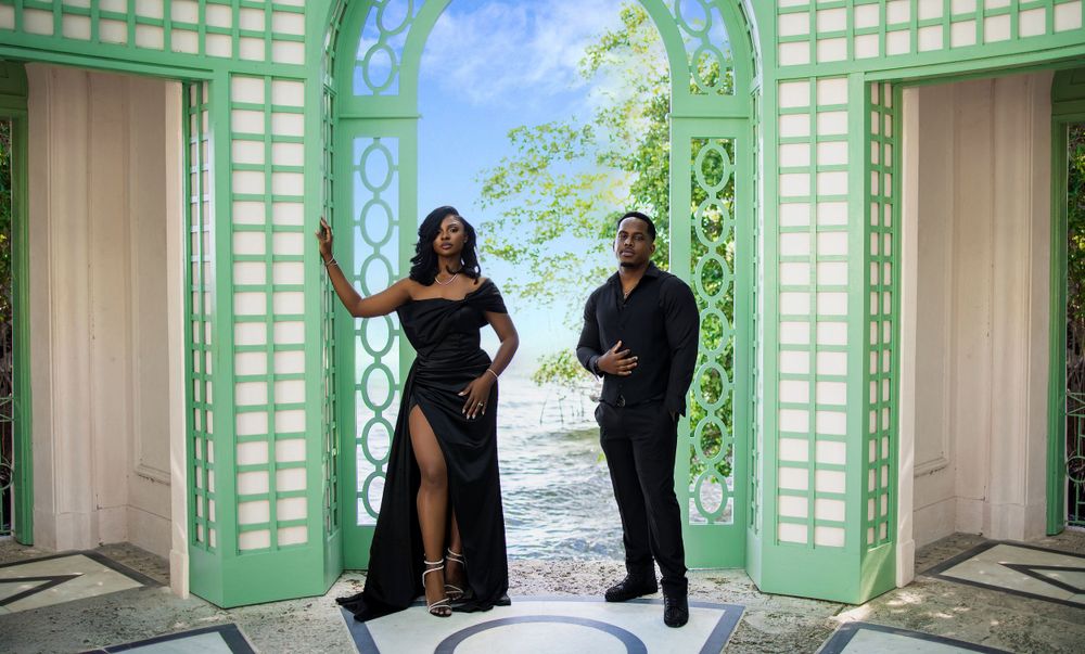 Couple posed against tall green shutters