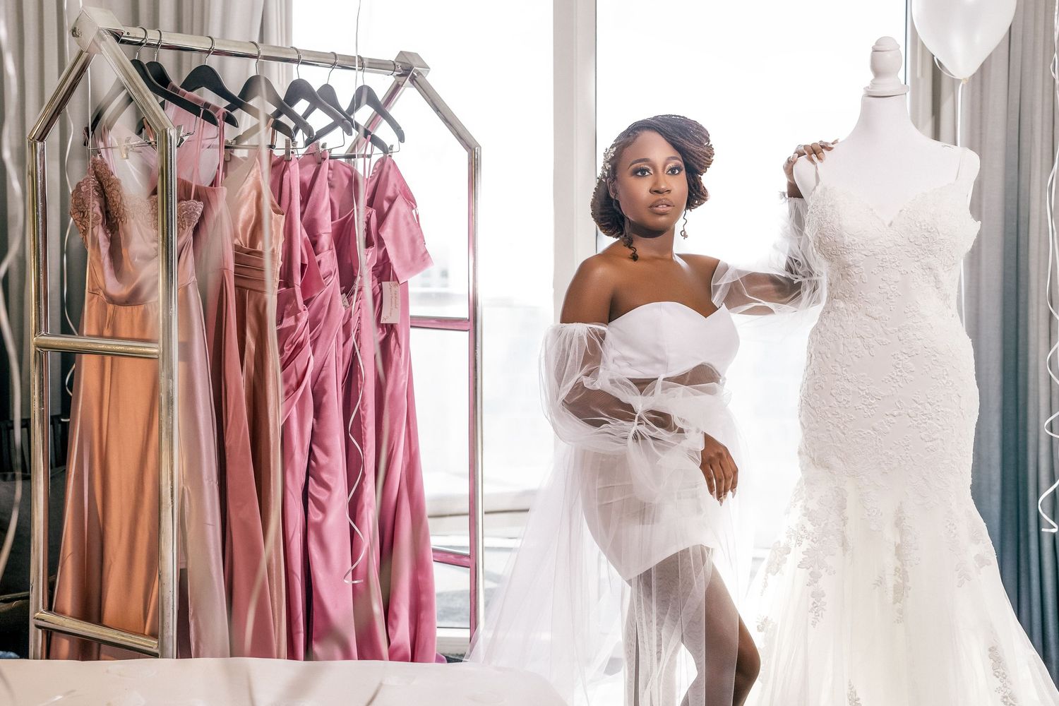 Bride beside a rack of bridesmaid dresses