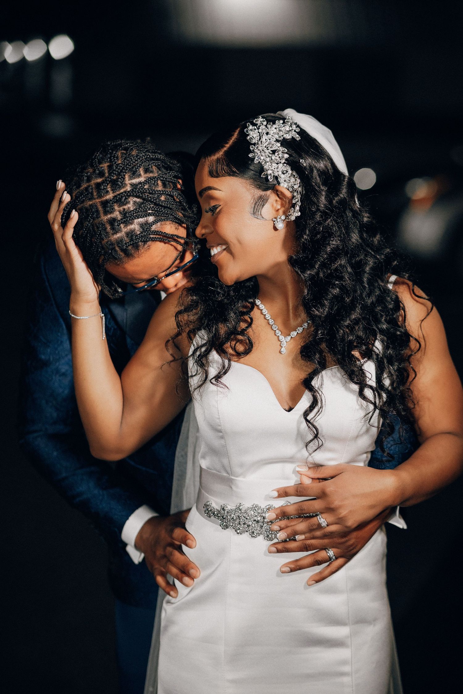 Bride in a crystal headpiece resting against her groom