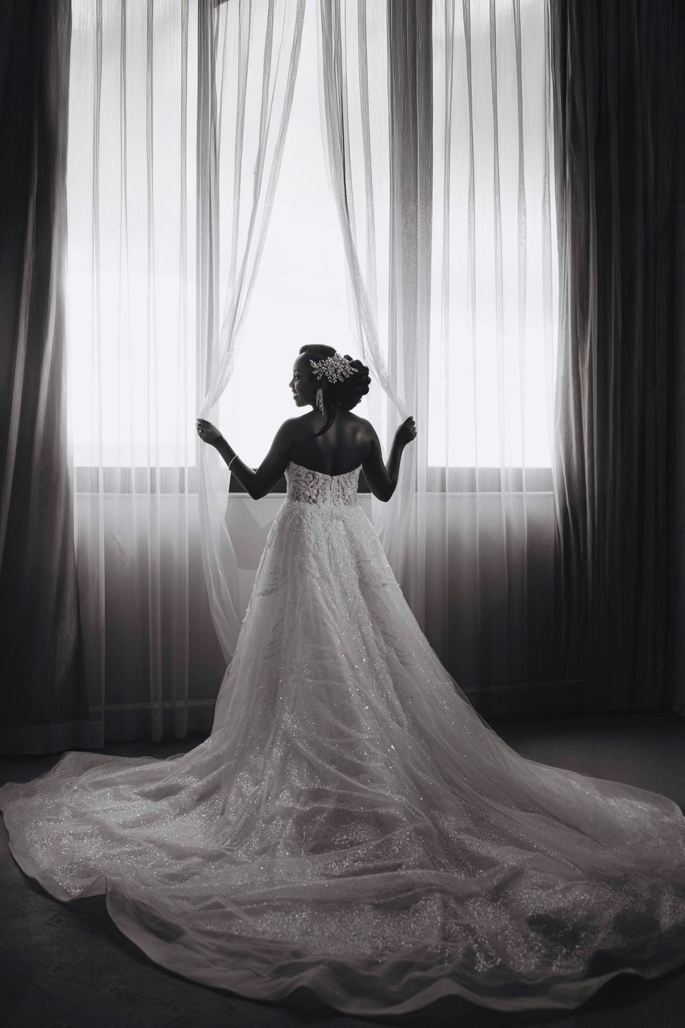 Bride in silhouette behind a sheer curtain